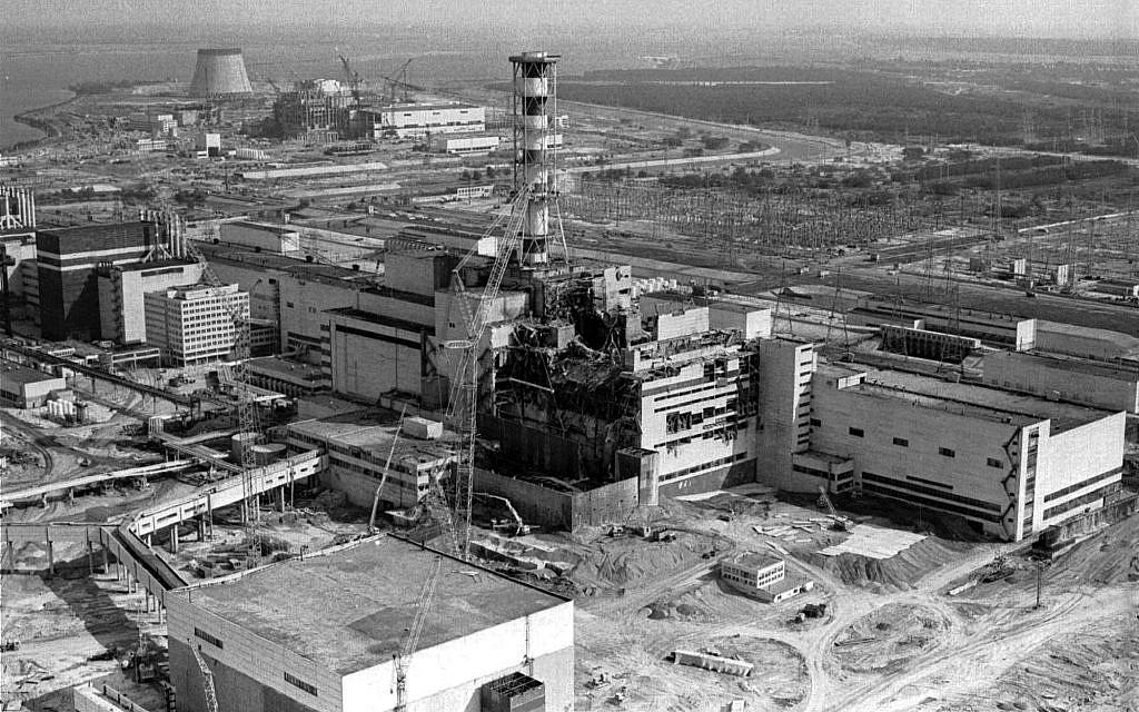 Widok z powietrza na Czarnobylską elektrownię atomową w 1986 r. Z pośród 3 fotografów TASS będących na pokładzie śmigłowca w momencie zrobienia zdjęcia, dwu zmarło na choroby powiązane z radiacją a jeden odczuwał efekty aż do swojej śmierci w wypadku samochodowym w 2015 r. Źródło: https://www.timesofisrael.com/when-hubris-meets-nuclear-fission-a-chernobyl-liquidators-warning-to-humanity/